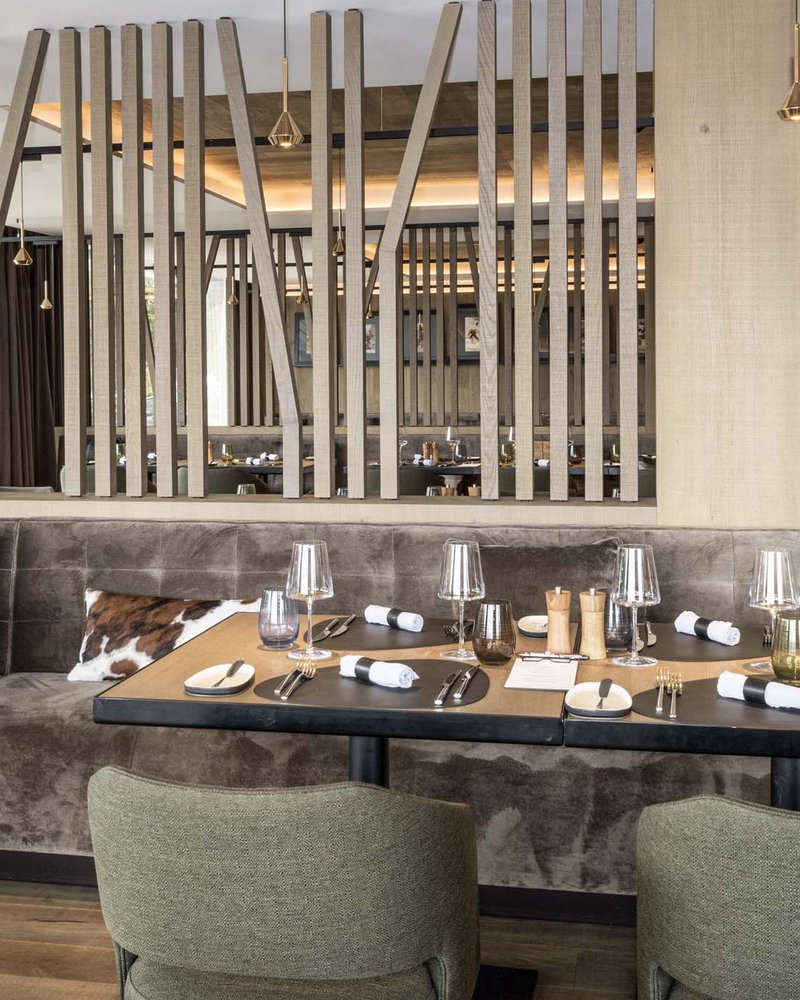 Your hotel in Val Pusteria/Pustertal: Olangerhof Modern restaurant interior with set tables and velvet banquette seating
