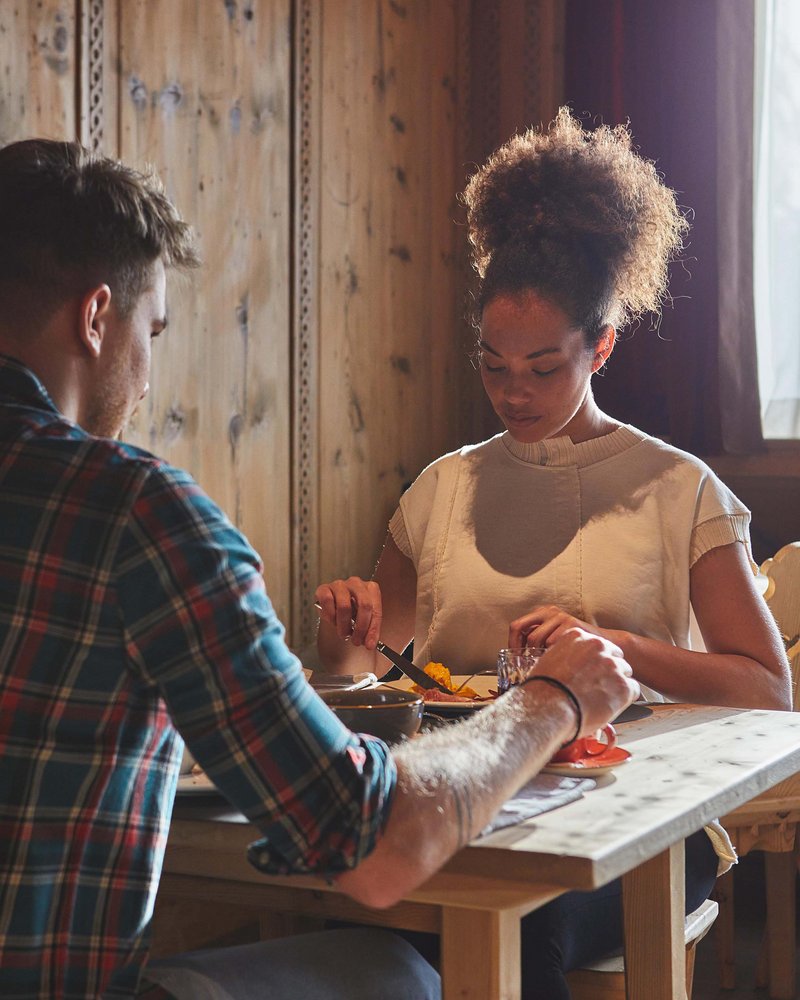 Your hotel in Val Pusteria/Pustertal: Olangerhof Couple having dinner together in a rustic room with natural light