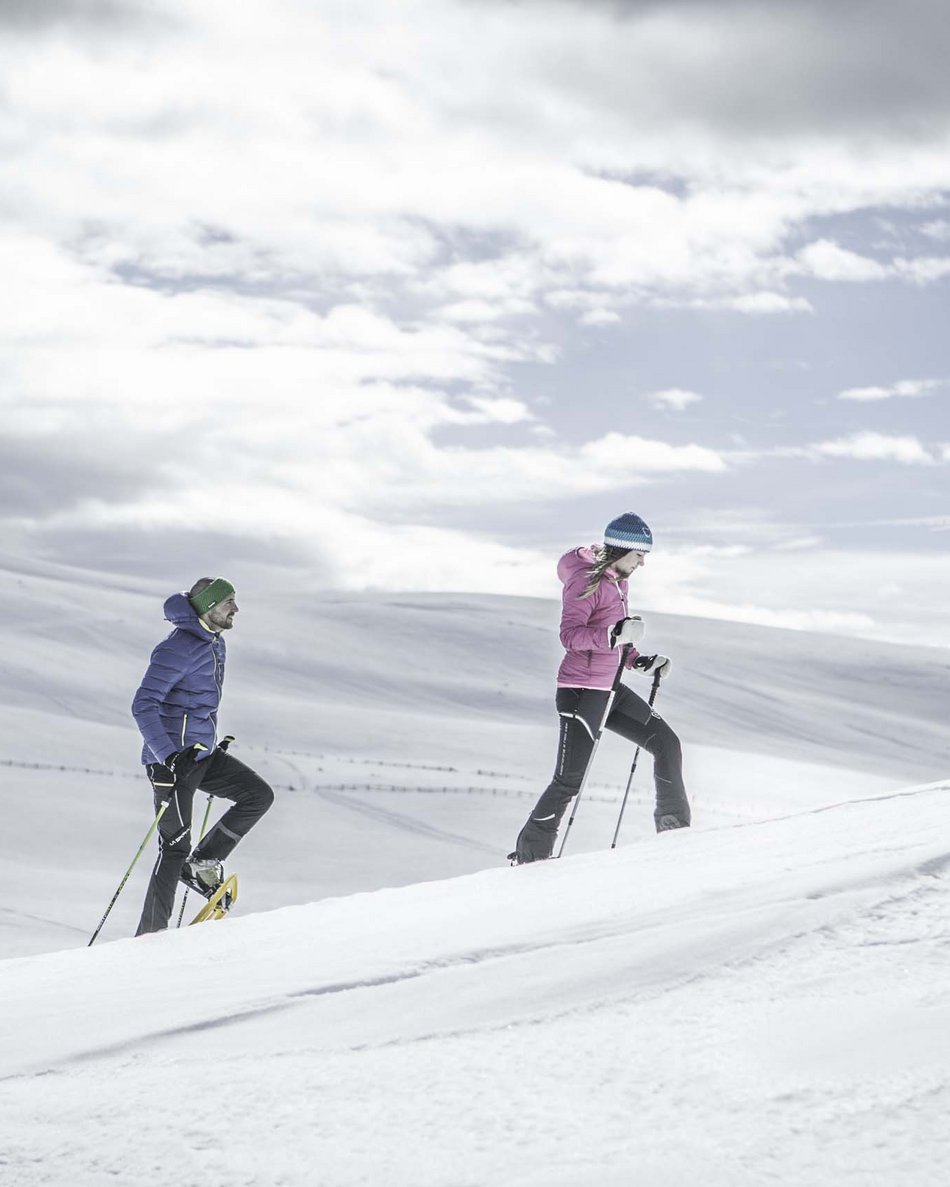 Your hotel in Val Pusteria/Pustertal: Olangerhof Three people snowshoeing in a snowy landscape