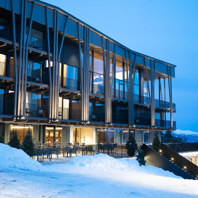 Your hotel in Val Pusteria/Pustertal: Olangerhof Modern hotel with balconies in snowy landscape at dusk