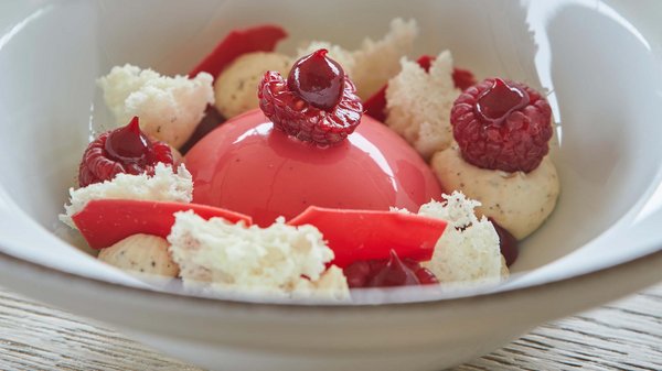 Hotels an der Piste in Südtirol mit Halbpension Rosa Dessert mit Himbeeren, Sahne und Baiserstücken in weißer Schüssel