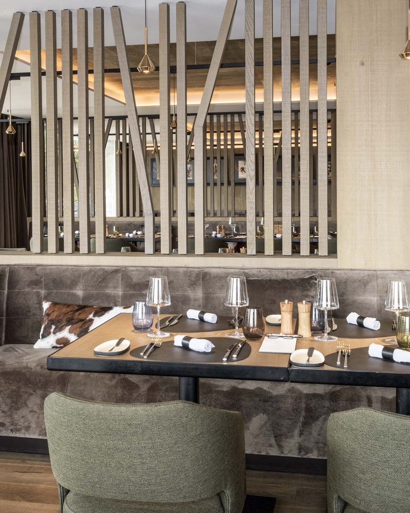 Il tuo hotel in Val Pusteria: Olangerhof Interno moderno di ristorante con tavoli apparecchiati e divanetti in velluto