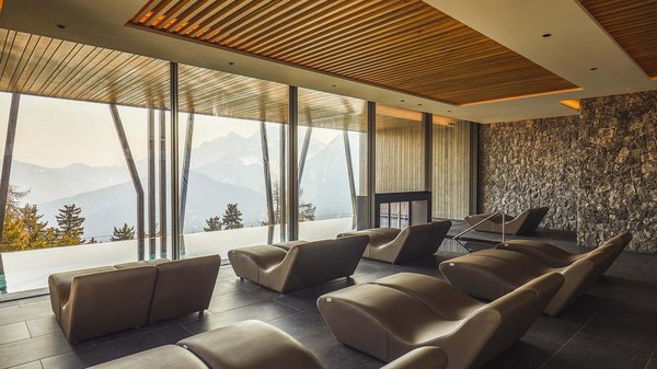 Dein Wellnesshotel am Kronplatz: Olangerhof Ruhebereich mit Liegen und Bergblick durch große Fenster