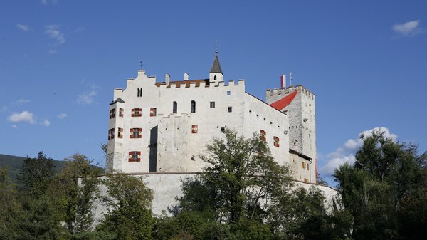 Olang: Wandern, Kunst und Kultur Weißes Schloss auf grünem Hügel unter blauem Himmel