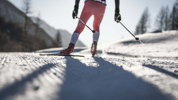 Kronplatz + Hotel an der Piste = Olangerhof Langläufer in rotem Anzug auf Schnee in den Bergen