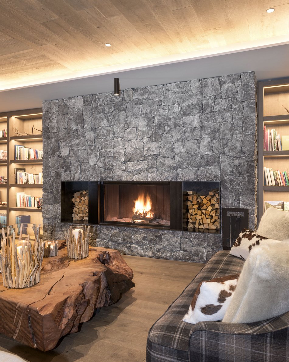 Hotels im Pustertal mit Halbpension: oh, so comfy! Wohnzimmer mit steinernem Kamin, Holztisch und Sofa mit Kissen