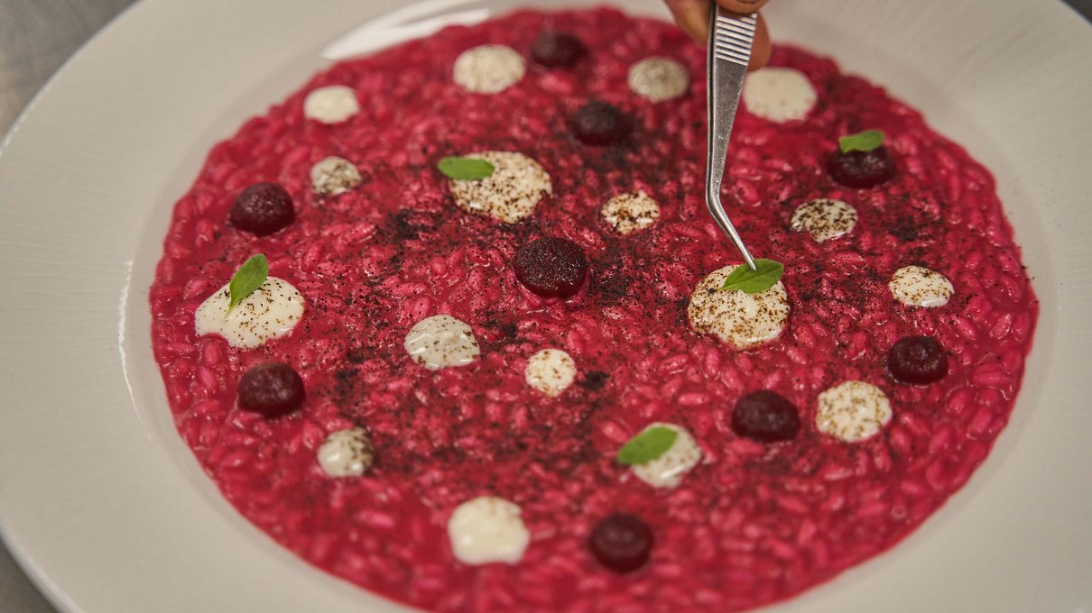 Deine Unterkunft im Pustertal: oh, wow! Roter Risotto mit weißer Creme, grünen Blättern und Garnitur