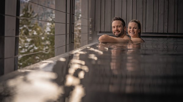 Hotel in Plan de Corones con piscina: il tuo Olangerhof Coppia rilassata in una piscina con vista sulla natura innevata