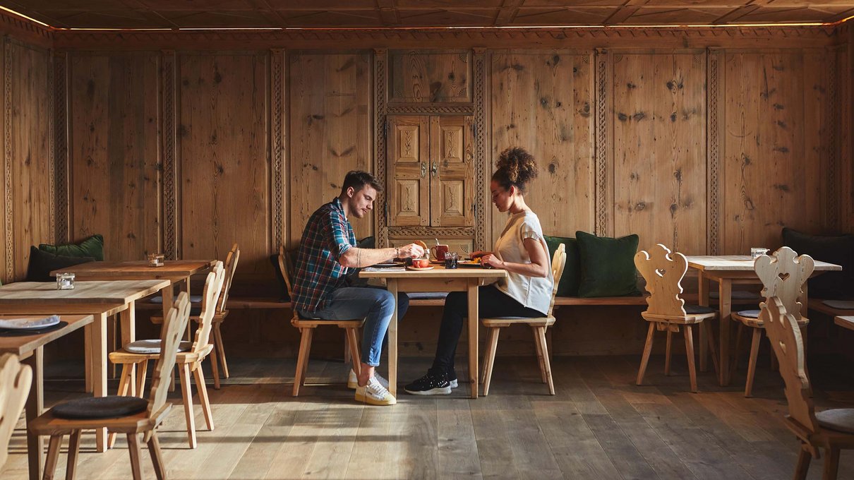 Deine Unterkunft im Pustertal: oh, wow! Paar isst in rustikalem Restaurant mit Holzmöbeln