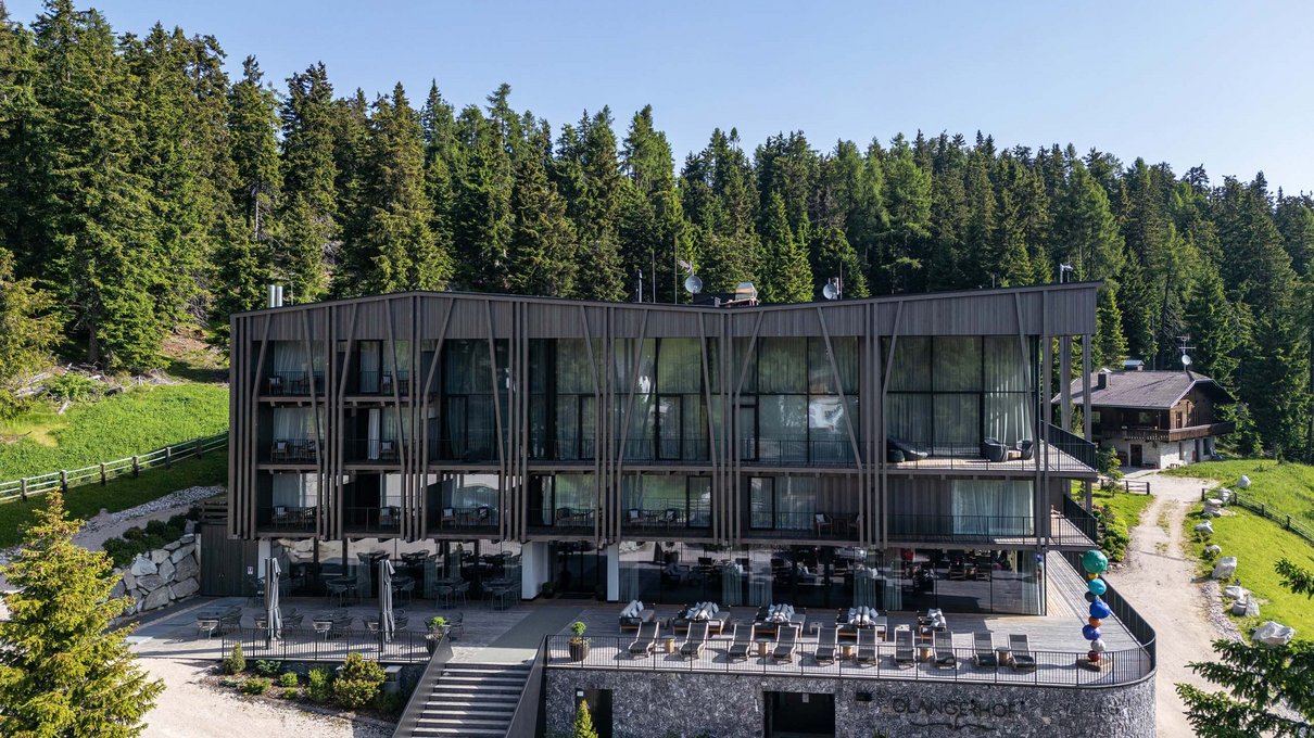 Deine Unterkunft im Pustertal: oh, wow! Modernes Hotel umgeben von grünen Bäumen in bergiger Landschaft