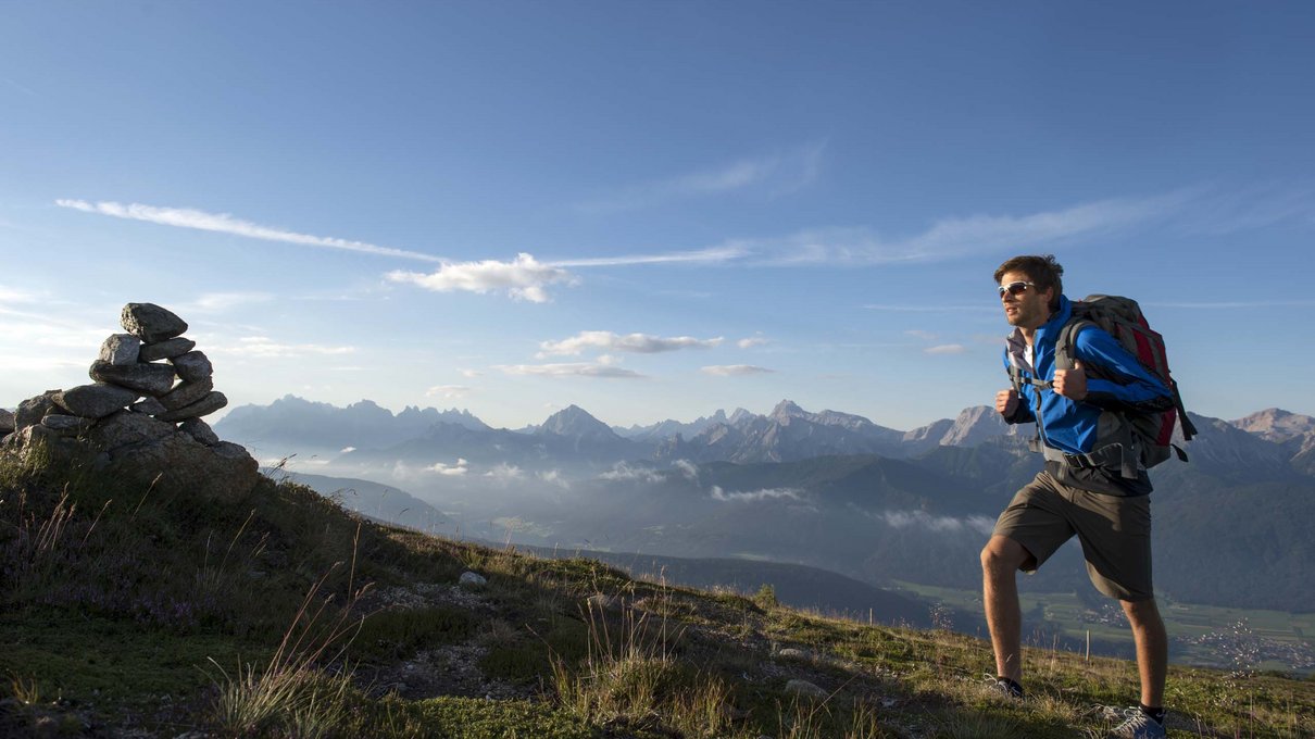 Deine Unterkunft im Pustertal: oh, wow! Wanderer mit Rucksack beim Bergwandern im Sonnenuntergang