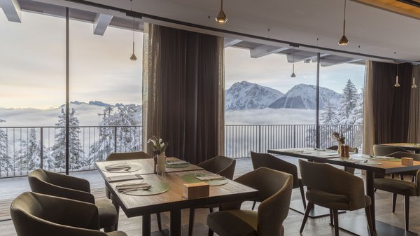 Dein Hotel in Olang: Willkommen im Olangerhof! Speisesaal mit Panoramablick auf verschneite Berge durch große Fenster