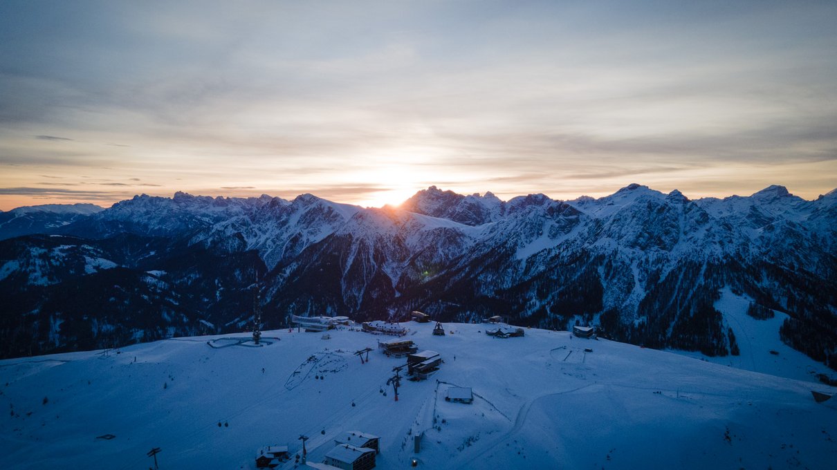 Il tuo alloggio in Val Pusteria: rifatti gli occhi! Tramonto sulle cime innevate delle Dolomiti con impianti sciistici in primo piano