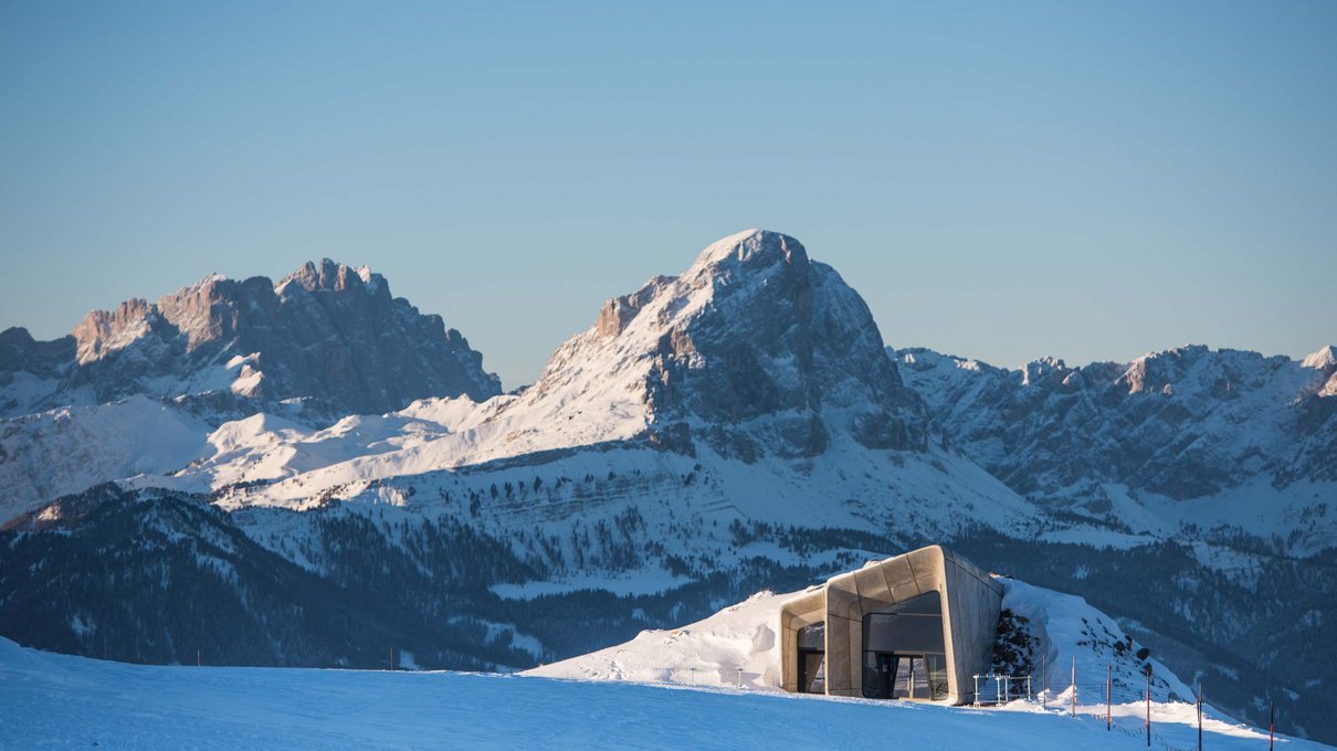 Deine Unterkunft im Pustertal: oh, wow! Verschneite Landschaft mit modernem Gebäude und Bergen im Hintergrund