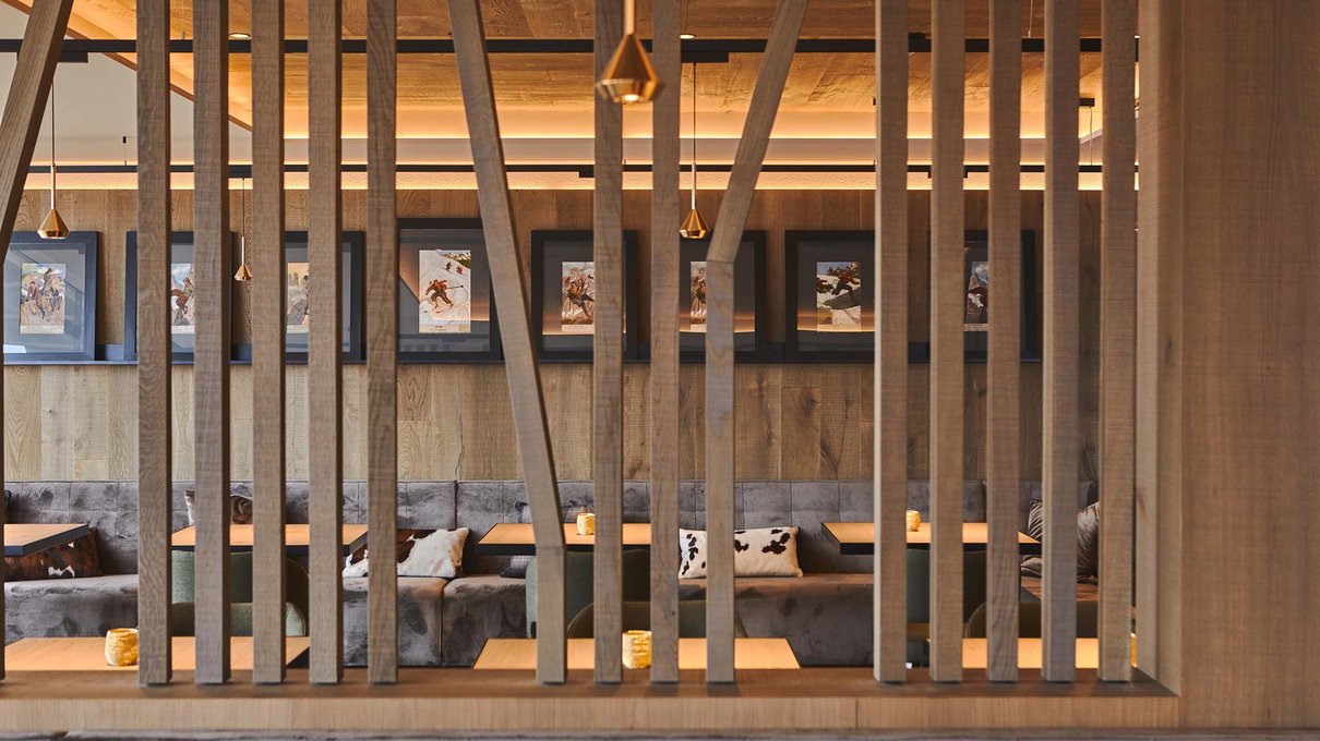 Deine Unterkunft im Pustertal: oh, wow! Innenaufnahme eines modernen Restaurants mit Holztrennwänden und Bildern an der Wand