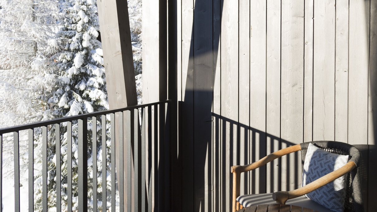Deine Unterkunft im Pustertal: oh, wow! Holzbalkon mit Stühlen und Tisch, Blick auf verschneite Bäume