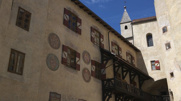Olang: Wandern, Kunst und Kultur Fassade eines historischen Schlosses mit verzierten Fenstern und blauem Himmel