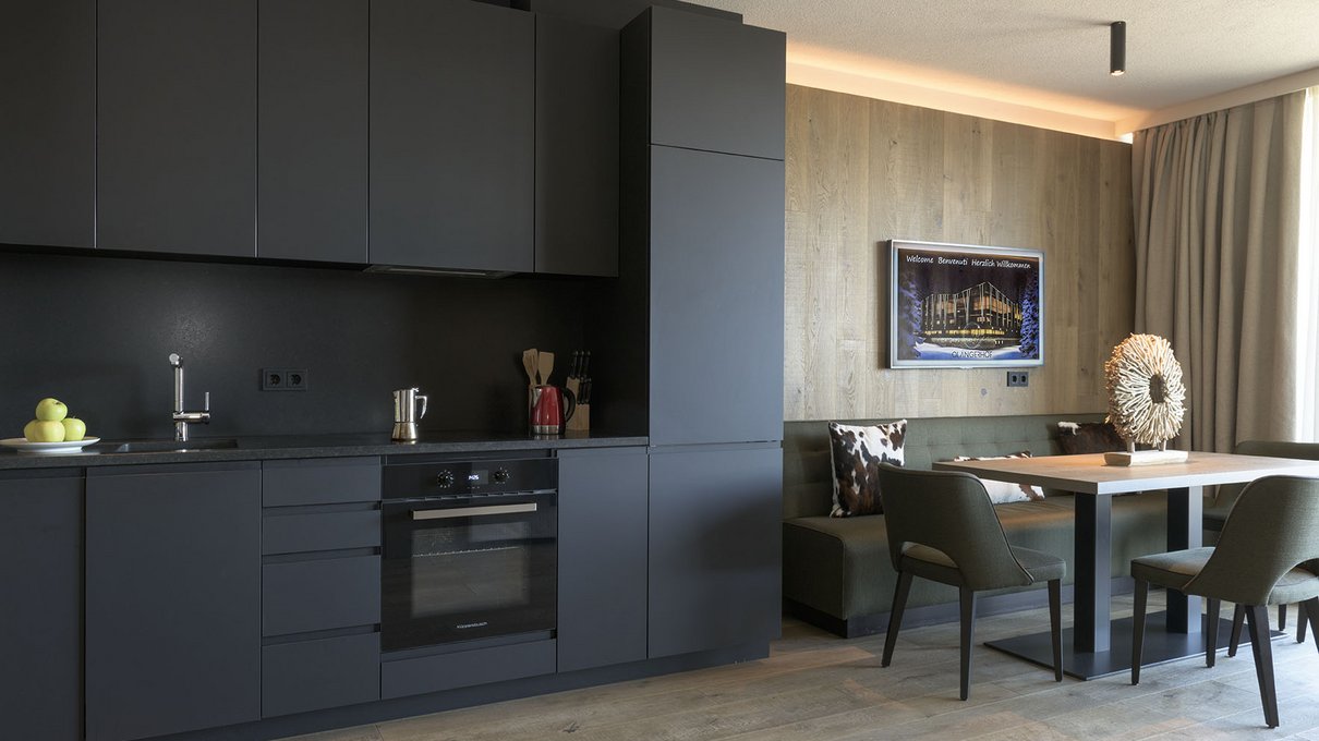 Deine Unterkunft im Pustertal: oh, wow! Moderne schwarze Küche mit Esstisch und Sofa