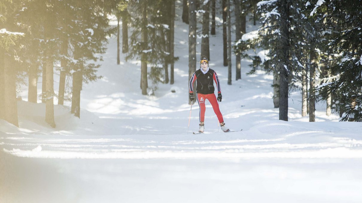 Deine Unterkunft im Pustertal: oh, wow! Skifahrer in roter Kleidung auf verschneiter Piste im Wald