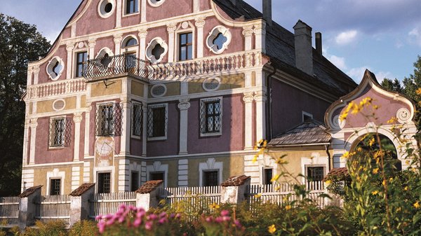 Olang: Wandern, Kunst und Kultur Historisches bemaltes Haus mit blühendem Garten im Vordergrund