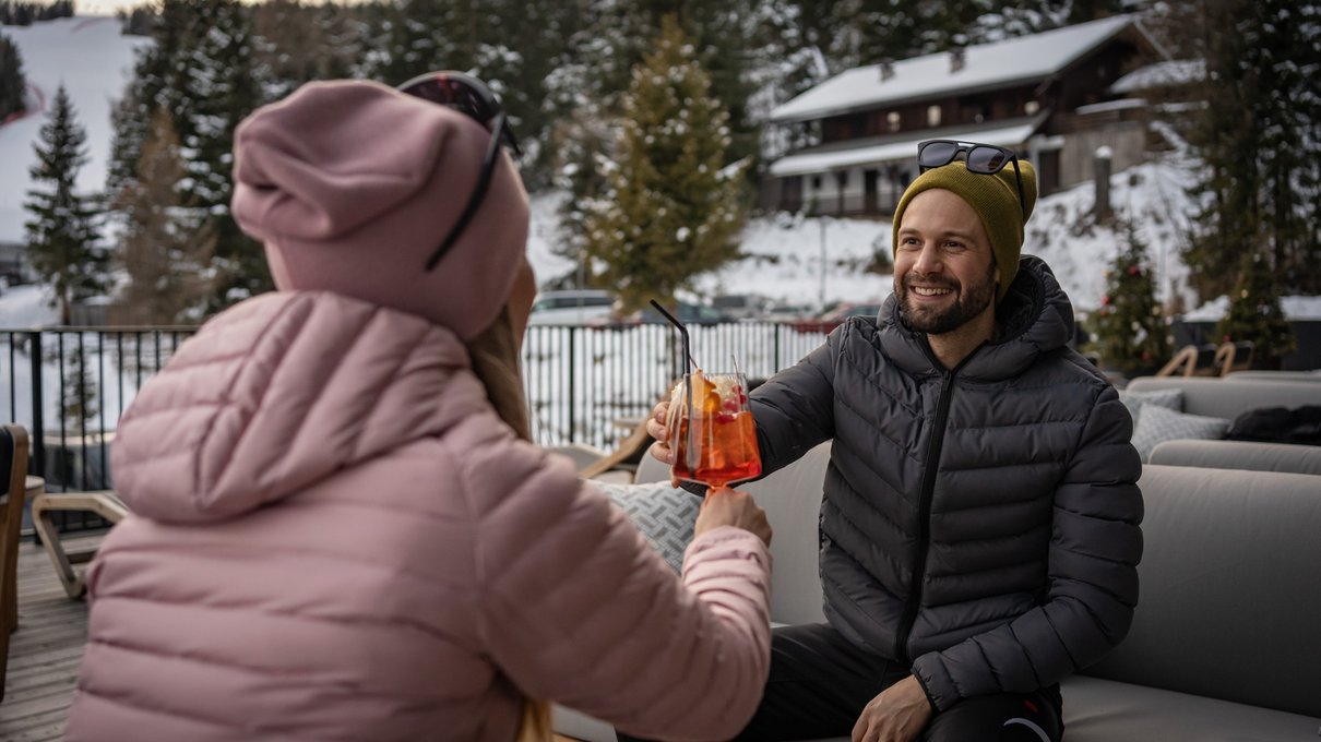 Deine Unterkunft im Pustertal: oh, wow! Paar stößt mit Getränken in schneebedeckter Outdoor-Umgebung an