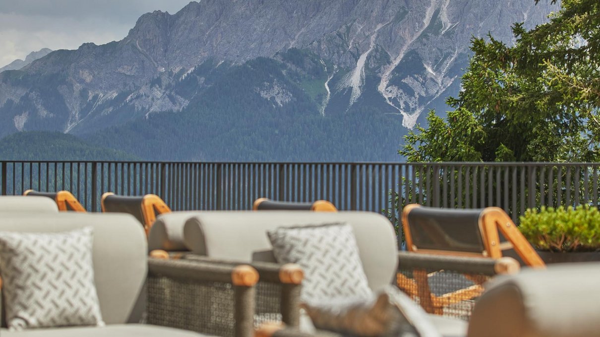 Deine Unterkunft im Pustertal: oh, wow! Terrasse mit Sofas und Blick auf felsige Berge unter bewölktem Himmel