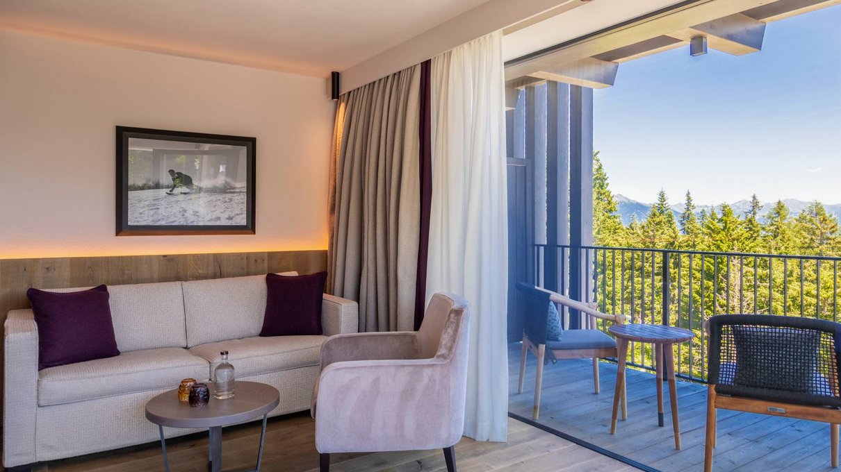 Deine Unterkunft im Pustertal: oh, wow! Wohnzimmer mit Sofa, Sessel und Balkon mit Bergblick
