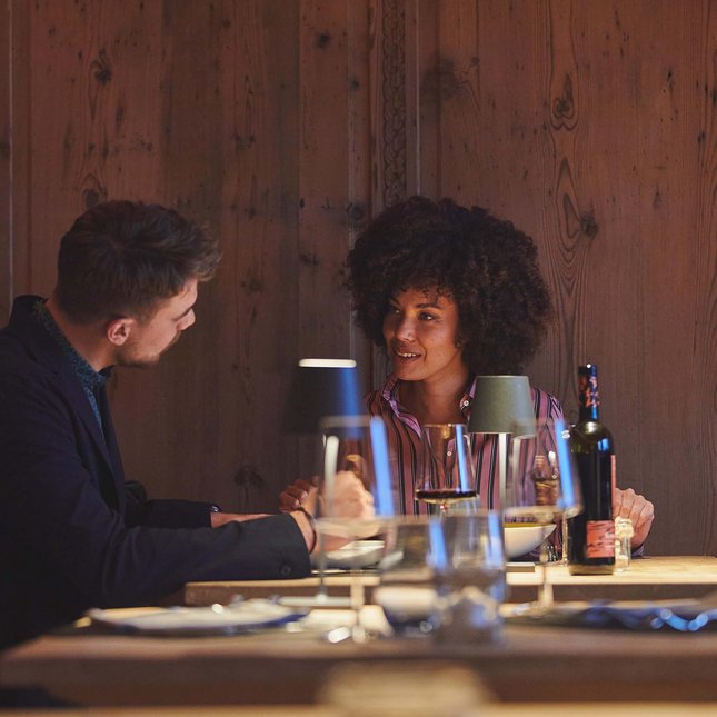 Val Pusteria and your hotel with half board: what a pairing! Couple talking during dinner in a cozy restaurant