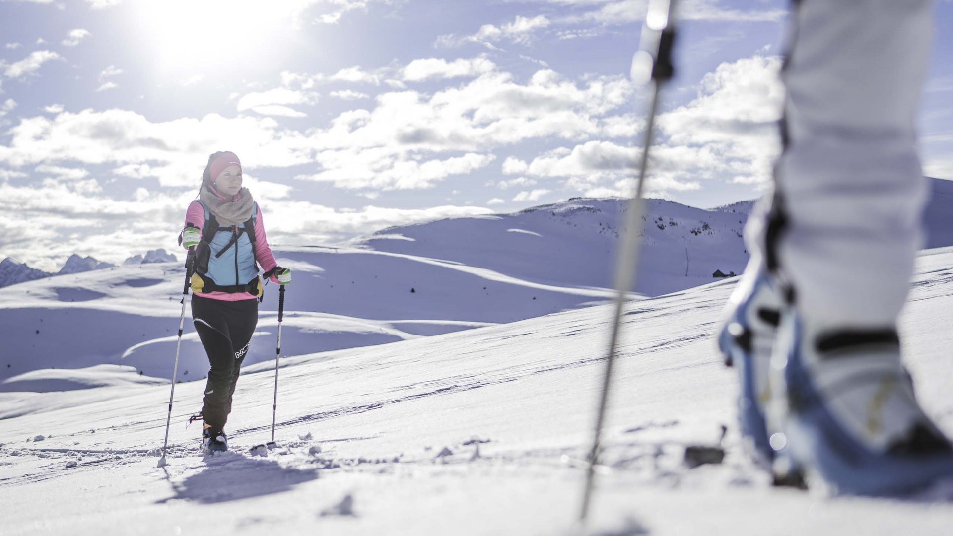 Kronplatz + Hotel an der Piste = Olangerhof Person beim Skifahren mit bunter Kleidung in sonniger verschneiter Landschaft