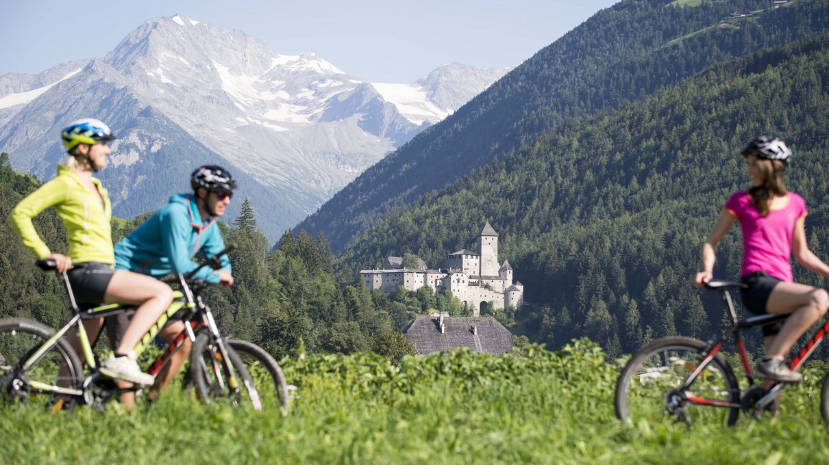Deine Unterkunft im Pustertal: oh, wow! Radfahrer mit Bergen und Schloss im Hintergrund