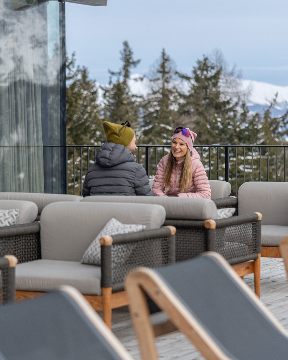 A Valdaora: l’hotel da “oh” Coppia seduta su poltrone su terrazza di montagna innevata