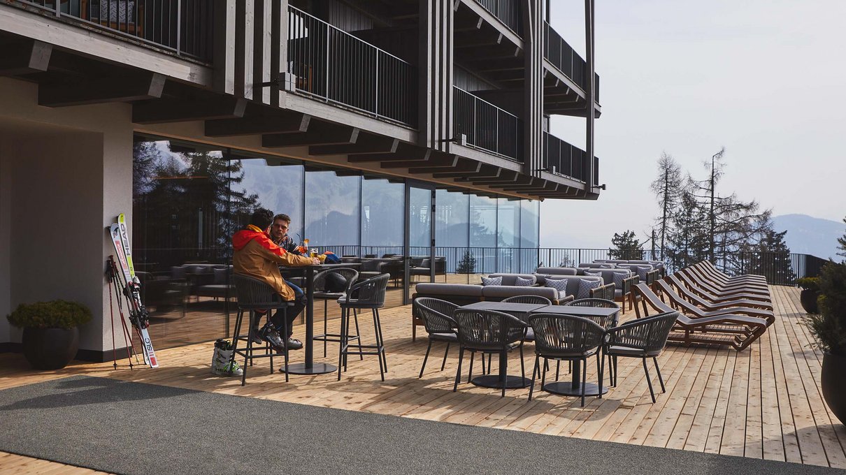Deine Unterkunft im Pustertal: oh, wow! Holzterrasse mit Stühlen, Tischen und zwei sitzenden Personen