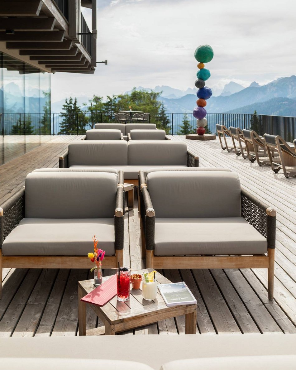 Hotels in Olang gesucht? Terrasse mit Sofas und Getränken vor Bergblick
