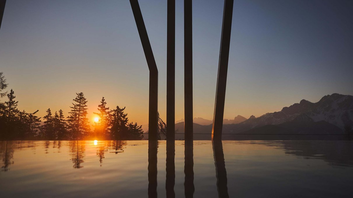 Deine Unterkunft im Pustertal: oh, wow! Sonnenuntergang hinter Bäumen und Bergen, Spiegelung im Außenpool