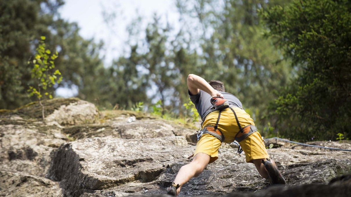Deine Unterkunft im Pustertal: oh, wow! Mann klettert an einem Felsen im Freien mit gelber Hose