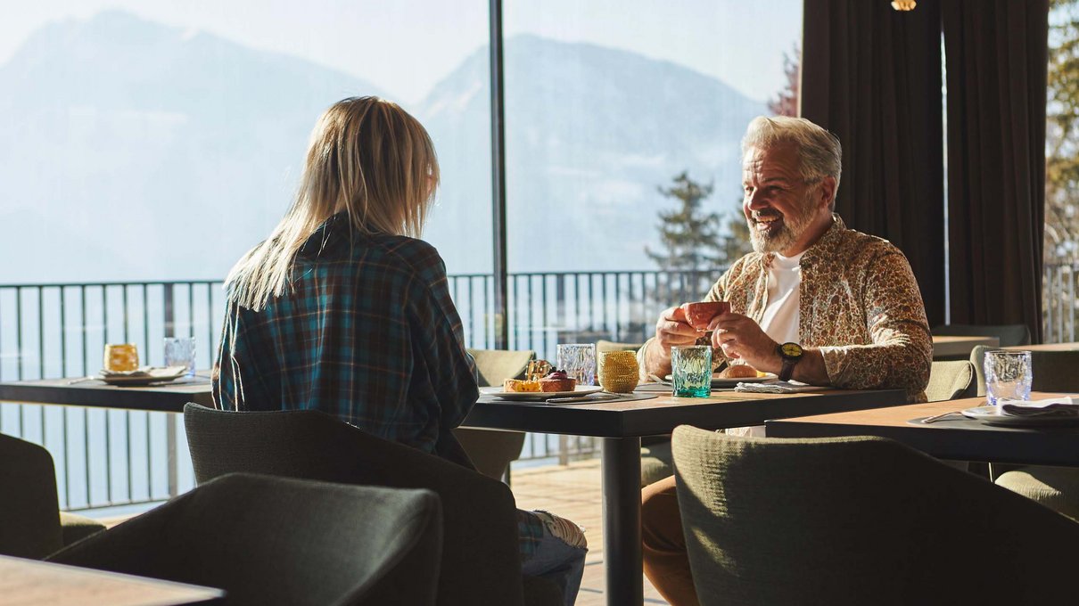 Deine Unterkunft im Pustertal: oh, wow! Zwei Personen trinken Kaffee in einem Restaurant mit Bergblick