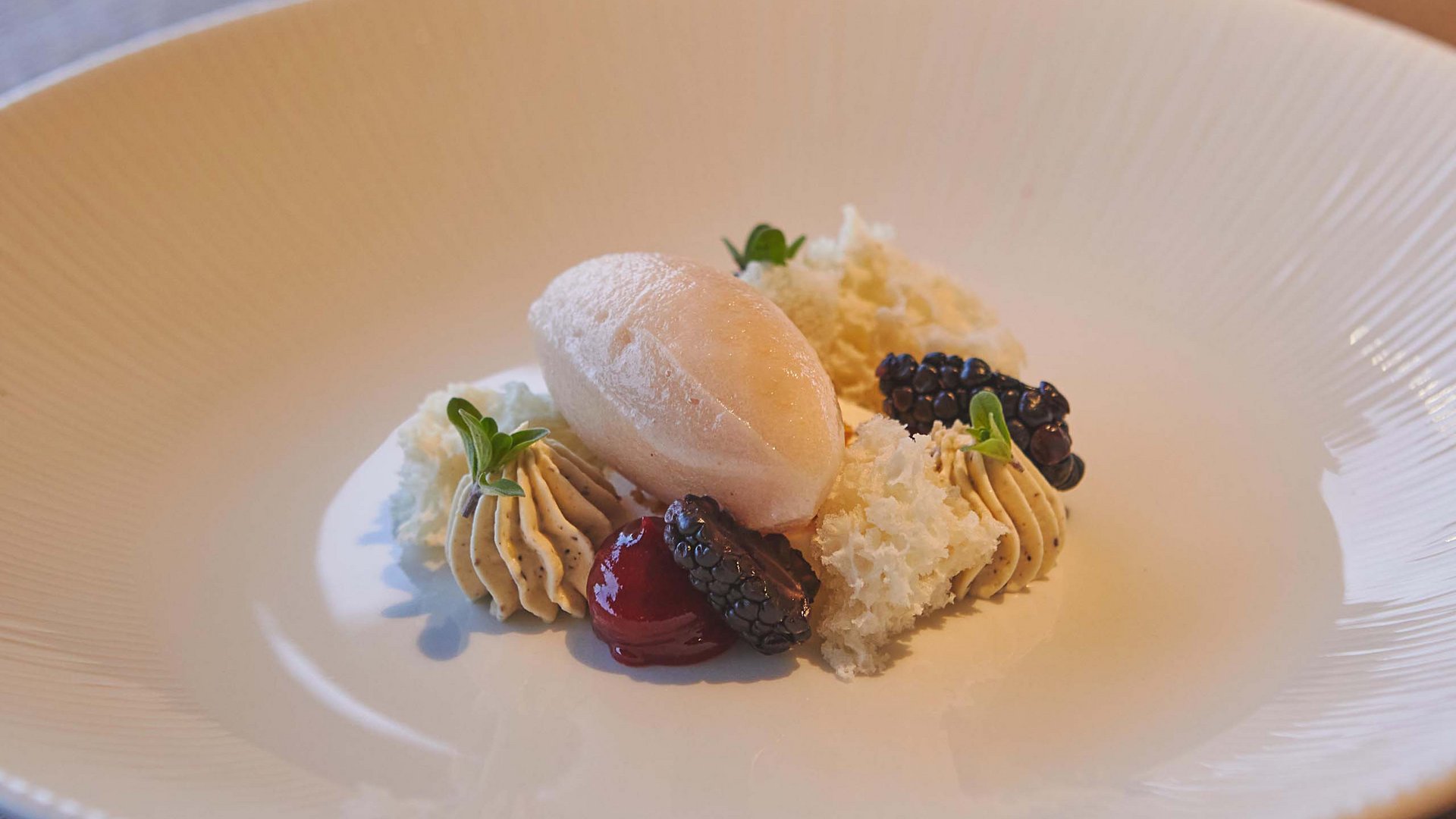 Hotel near Plan de Corones/Kronplatz: more flavour! Gourmet dessert with mousse, ice cream, blackberries, and green garnishes