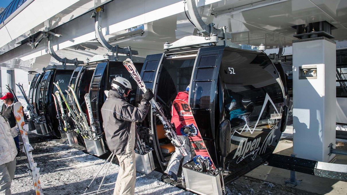 Deine Unterkunft im Pustertal: oh, wow! Personen steigen mit Skiausrüstung in Gondel an Skistation ein