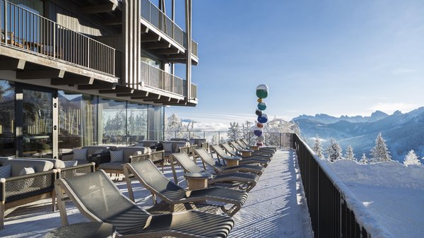 A Valdaora: l’hotel da “oh” Terrazza soleggiata con sdraio e poltrone con vista montagna innevata