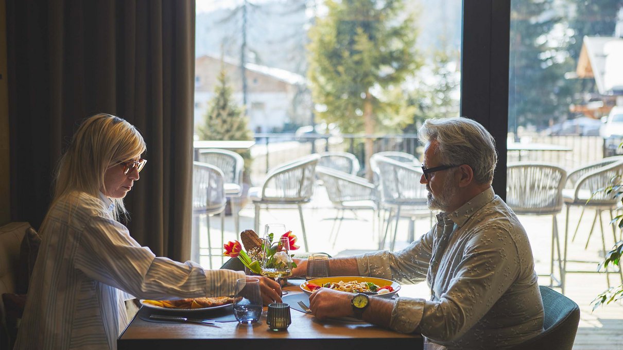 Deine Unterkunft im Pustertal: oh, wow! Paar isst in einem Restaurant mit Blick auf verschneite Landschaft