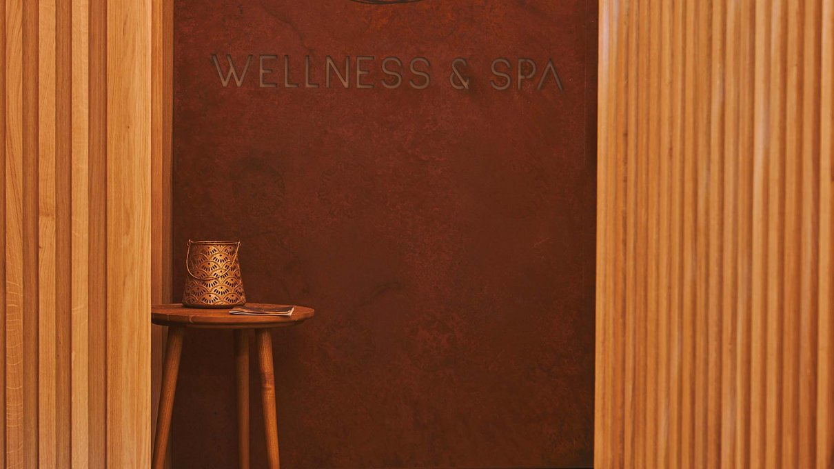 Deine Unterkunft im Pustertal: oh, wow! Eingang eines Wellness- und Spa-Bereichs mit Holzmöbeln und gedämpfter Beleuchtung