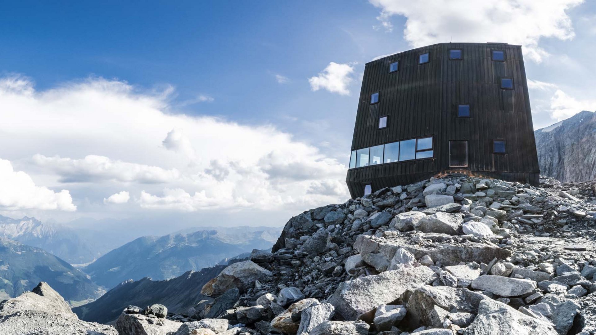Olang in summer: sunny days at Olangerhof Modern mountain refuge on rocky terrain with panoramic views and bright sun