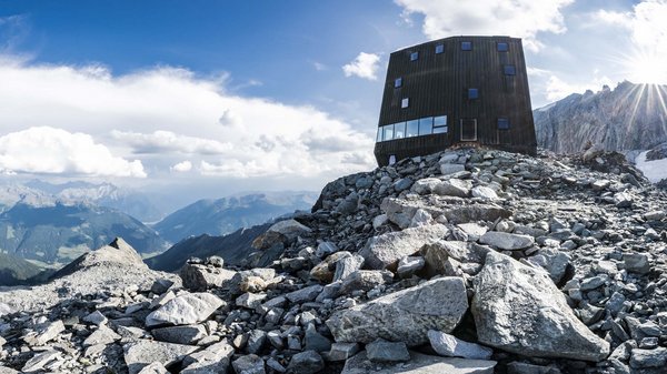 Olang: Wandern, Kunst und Kultur Modernes Schutzhaus auf felsigem Bergplateau mit Panoramablick und sonnigem Himmel