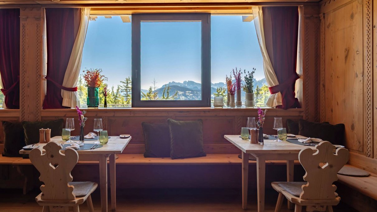 Deine Unterkunft im Pustertal: oh, wow! Innenraum eines Holzrestaurants mit Bergblick und gedeckten Tischen