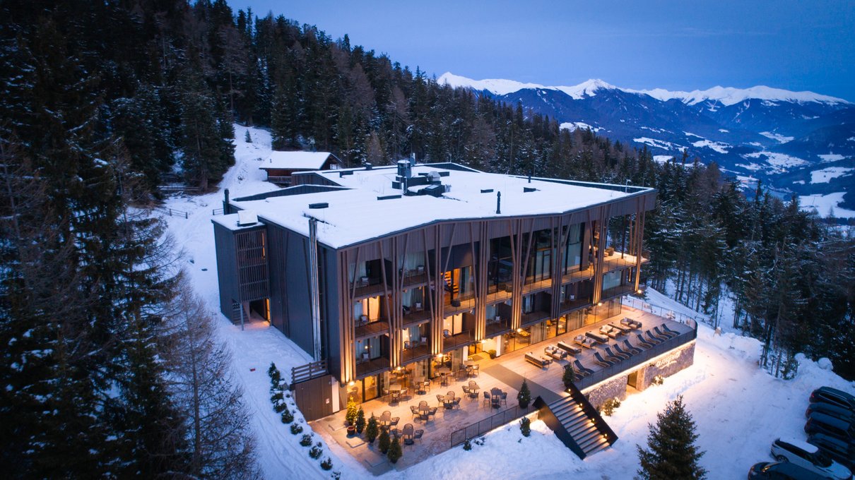 Deine Unterkunft im Pustertal: oh, wow! Modernes Hotel im Schnee mit verschneiten Bergen und Bäumen