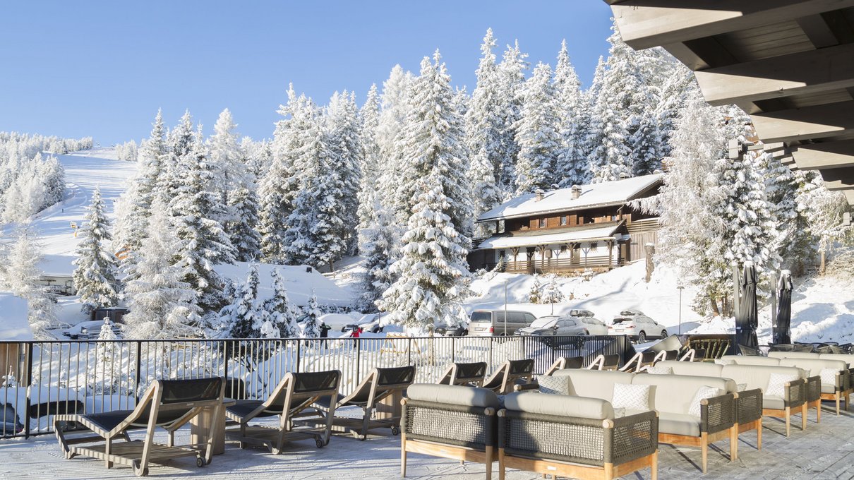 Deine Unterkunft im Pustertal: oh, wow! Terrasse mit Liegestühlen und Sofas mit Blick auf verschneite Bäume und Berge