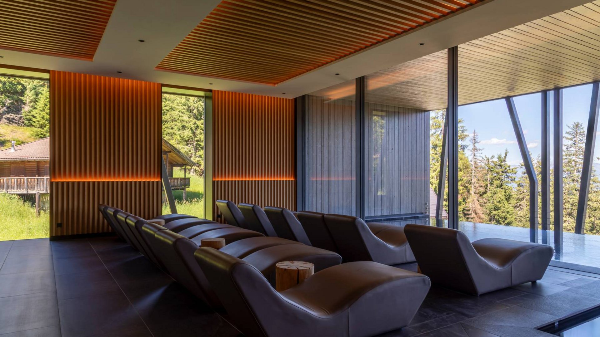 Dein Wellnesshotel am Kronplatz: Olangerhof Moderner Innenraum mit Liegestühlen und Panoramablick auf die Natur