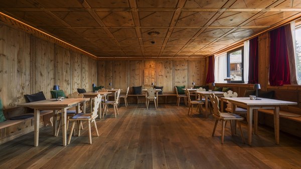 Hotels an der Piste in Südtirol mit Halbpension Speisesaal aus Holz mit rustikalen Tischen und Stühlen