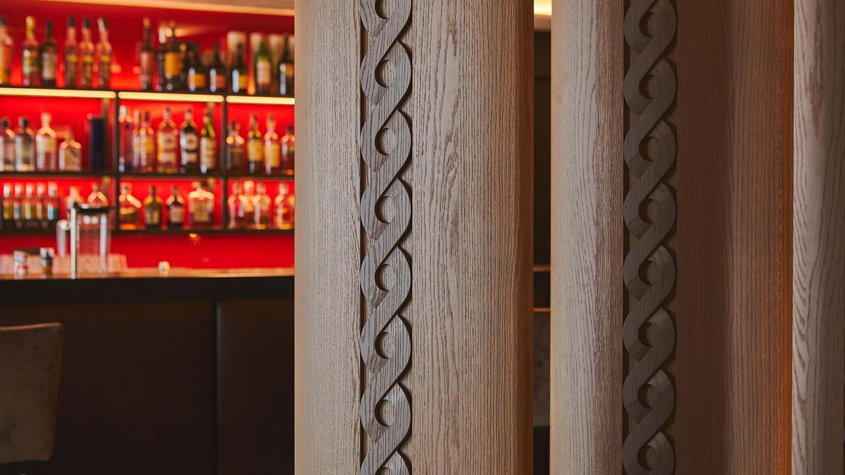 Deine Unterkunft im Pustertal: oh, wow! Bar mit dekorativem Holzwand und beleuchteten Flaschenregalen