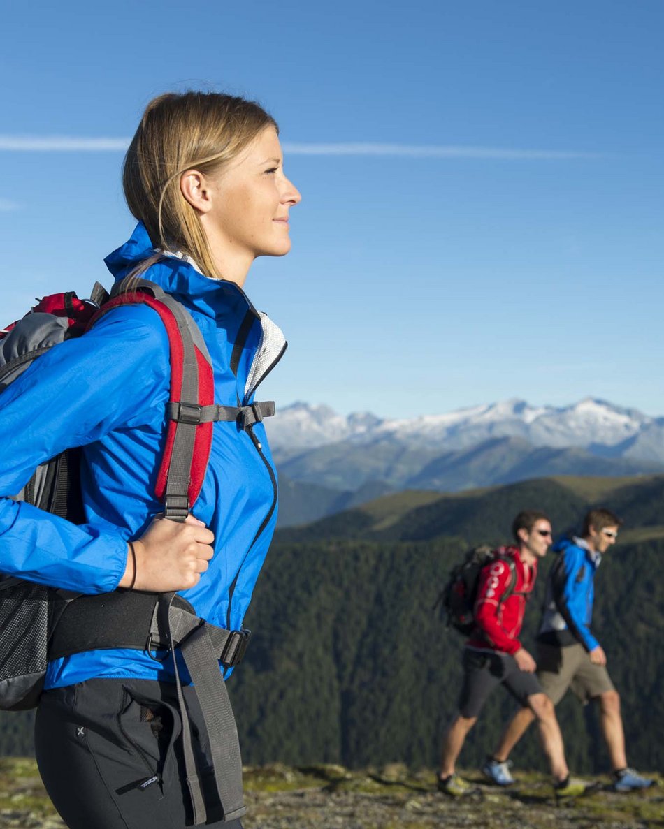 Olang in summer: sunny days at Olangerhof Woman hiking with backpack on sunny mountain trail